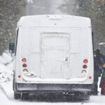 Asylum seekers board a bus after crossing into Canada from